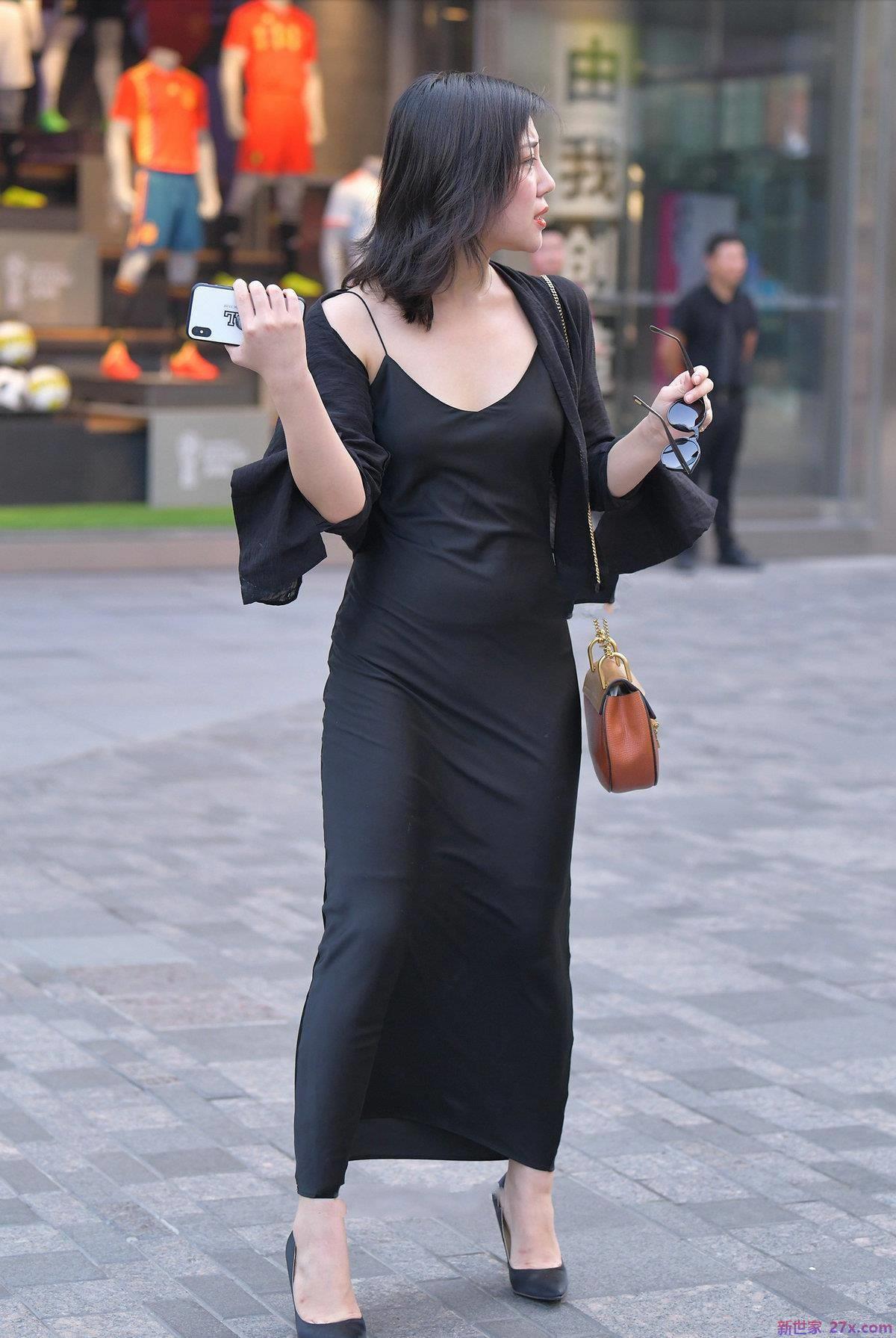 肩带的黑色丝绸裙看起来时尚有型，给人一种端庄的感觉。