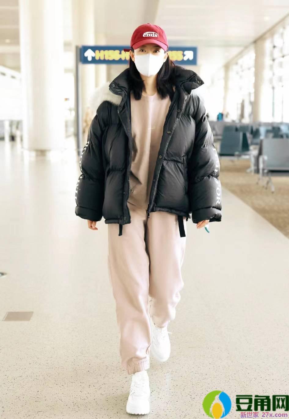 张小斐身穿黑色面包外套搭配卫衣走机场，休闲保暖又时髦